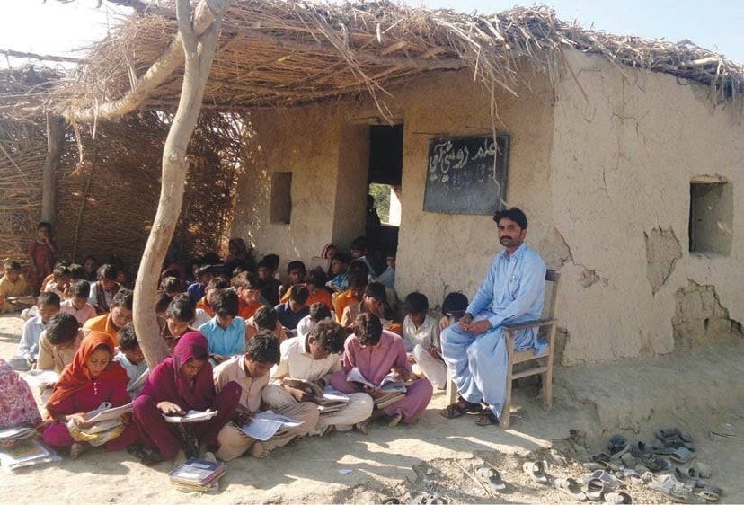 Students learning in an outdoor classroom in a village setting.